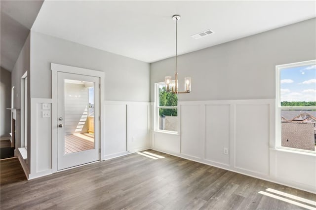 unfurnished dining area featuring dark hardwood / wood-style floors and a chandelier