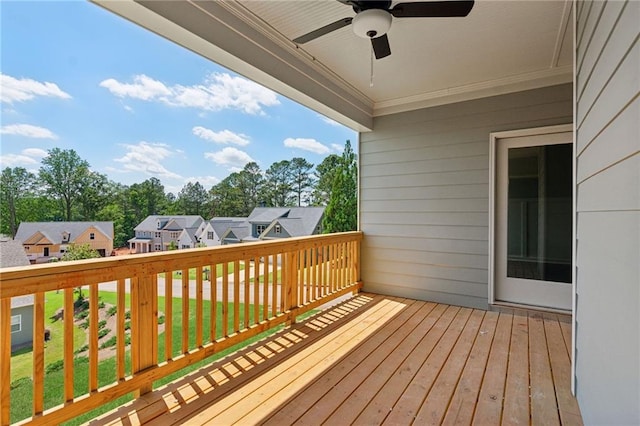 wooden terrace featuring ceiling fan and a lawn