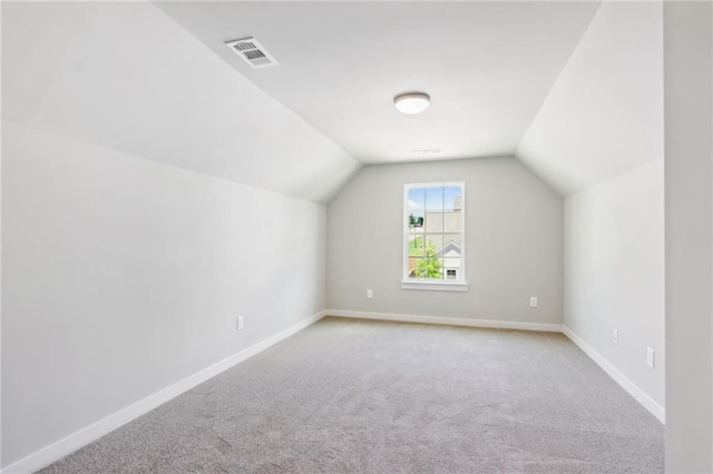 additional living space with lofted ceiling and light carpet