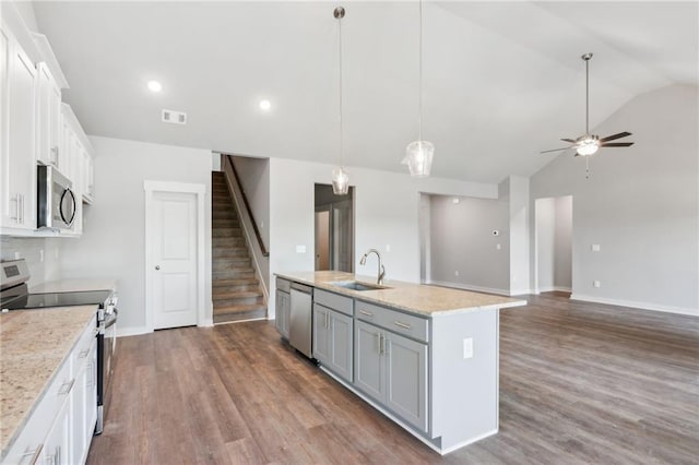 kitchen featuring pendant lighting, sink, white cabinetry, stainless steel appliances, and a center island with sink