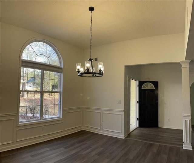 unfurnished dining area featuring a chandelier and dark hardwood / wood-style floors