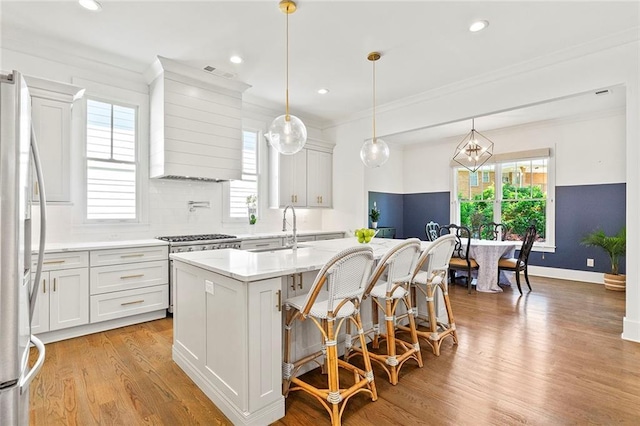 259 Sisson Ave, Atlanta, GA 30317 - kitchen featuring freestanding refrigerator, custom exhaust hood, light countertops, healthy amount of natural light, and ornamental molding