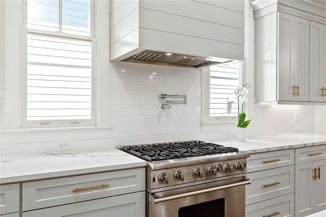 259 Sisson Ave, Atlanta, GA 30317 - kitchen featuring stainless steel stove, premium range hood, tasteful backsplash, and light stone counters
