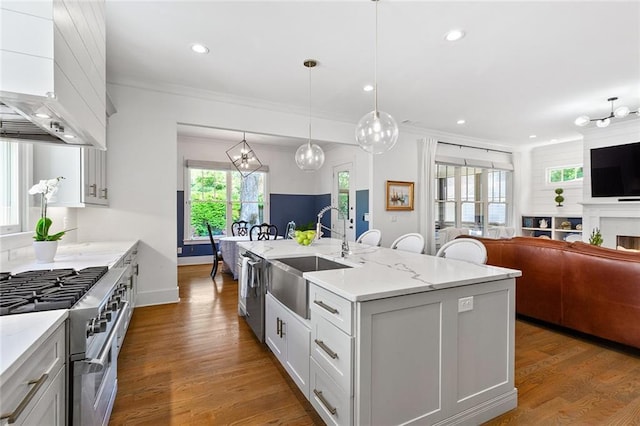 259 Sisson Ave, Atlanta, GA 30317 - kitchen with wall chimney exhaust hood, stainless steel appliances, open floor plan, crown molding, and an island with sink