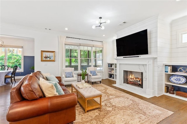 259 Sisson Ave, Atlanta, GA 30317 - living room with wood finished floors, a chandelier, ornamental molding, healthy amount of natural light, and a premium fireplace
