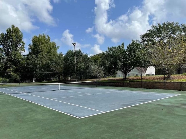 view of tennis court with community basketball court and fence