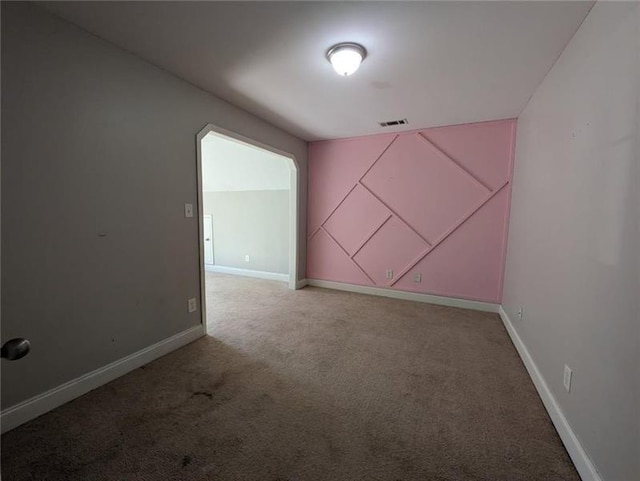 empty room featuring carpet floors, baseboards, and visible vents