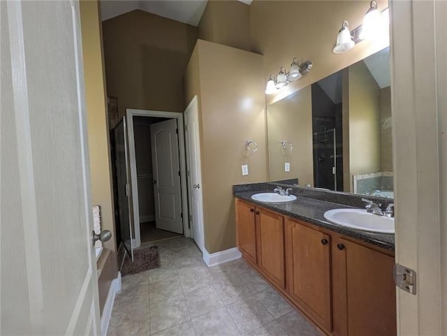 bathroom with vaulted ceiling, tile patterned flooring, a sink, and a shower with shower door