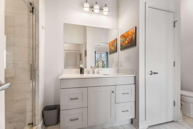 bathroom with vanity, a shower with shower door, and toilet