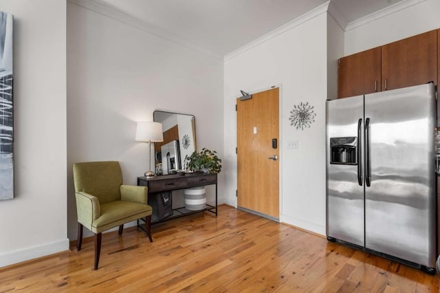 kitchen featuring crown molding, light wood-type flooring, and stainless steel refrigerator with ice dispenser