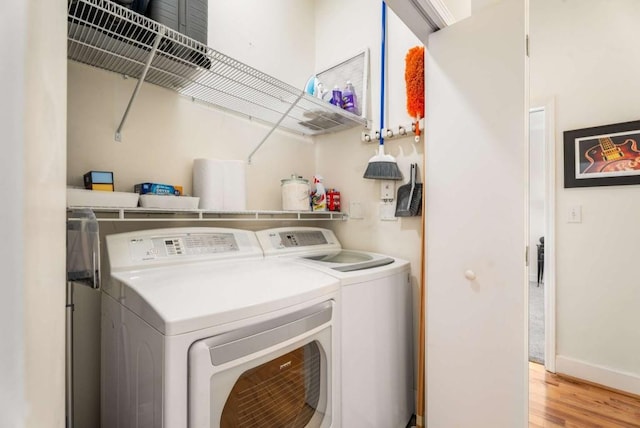 laundry area featuring washing machine and dryer and light hardwood / wood-style floors