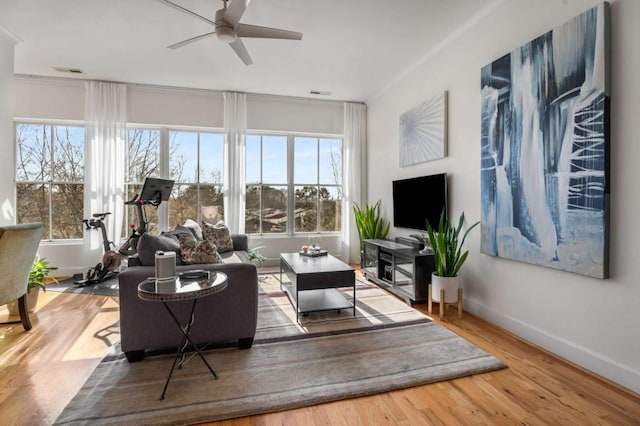 living room with wood-type flooring, a wealth of natural light, and ceiling fan