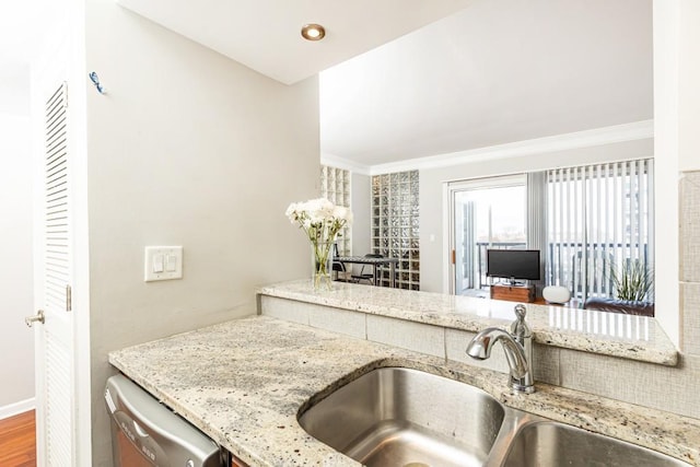 kitchen with dishwasher, wood-type flooring, light stone countertops, and sink