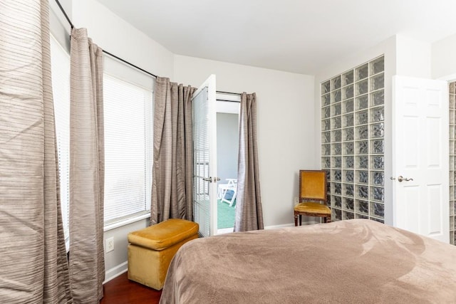 bedroom with multiple windows and dark hardwood / wood-style flooring