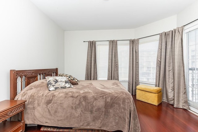 bedroom with dark hardwood / wood-style flooring and multiple windows