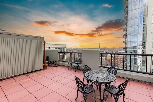 patio terrace at dusk featuring a balcony