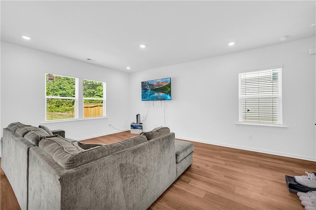 living room with light wood-type flooring and recessed lighting