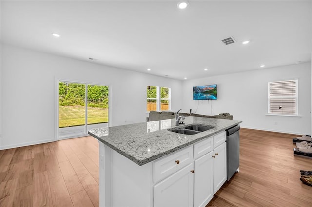 kitchen with visible vents, a center island with sink, dishwasher, a sink, and open floor plan