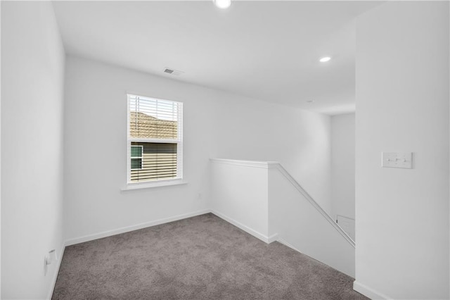 carpeted spare room featuring recessed lighting, baseboards, and visible vents