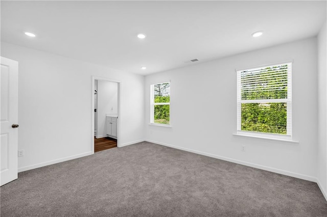 unfurnished bedroom featuring dark colored carpet, recessed lighting, and baseboards