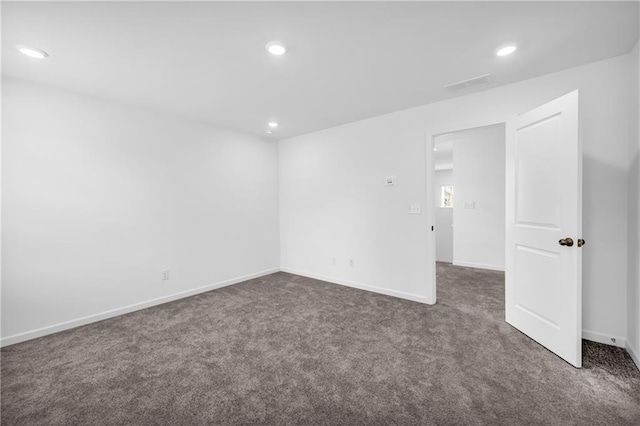 unfurnished room with recessed lighting, baseboards, dark colored carpet, and visible vents