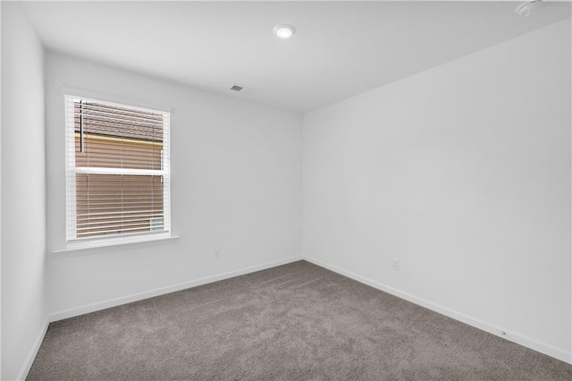 carpeted spare room featuring baseboards