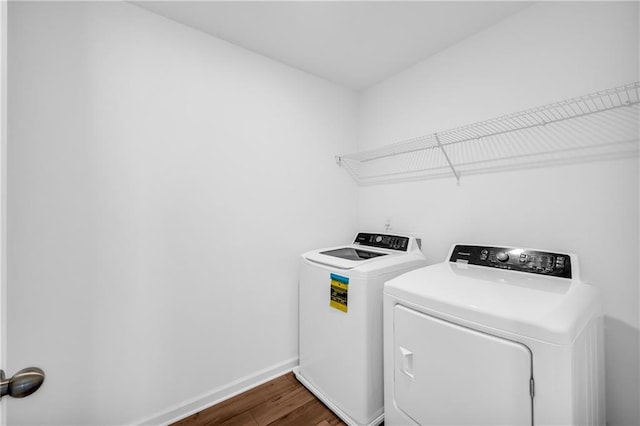 laundry area featuring independent washer and dryer, laundry area, dark wood finished floors, and baseboards