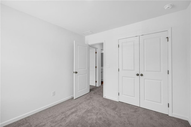 unfurnished bedroom with carpet flooring, baseboards, and a closet