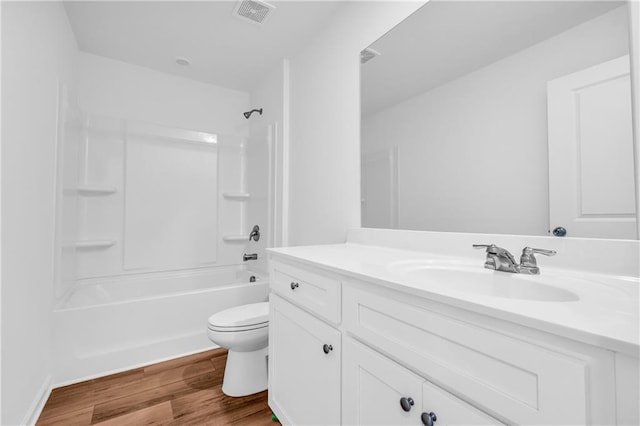 bathroom featuring vanity, visible vents, wood finished floors, bathing tub / shower combination, and toilet