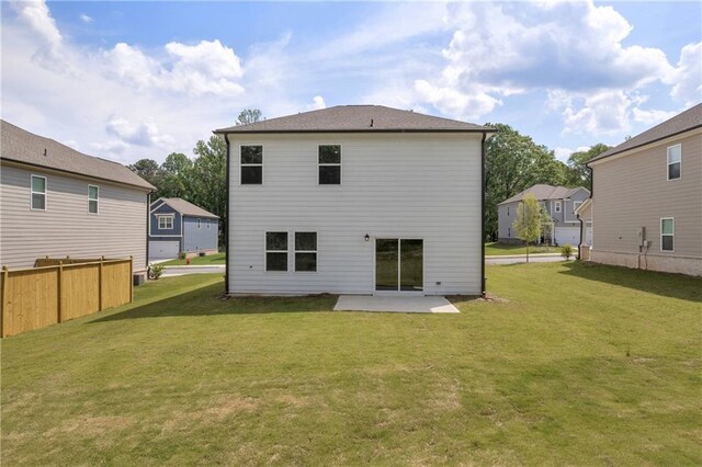 back of house featuring fence, a yard, a patio area, and a residential view
