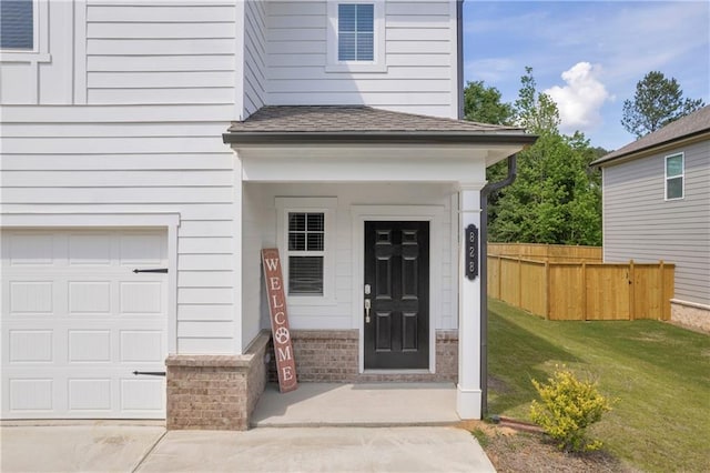 property entrance with a garage, fence, roof with shingles, brick siding, and a lawn