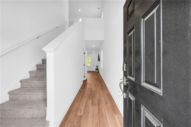 entrance foyer featuring light wood-style floors, recessed lighting, and stairs