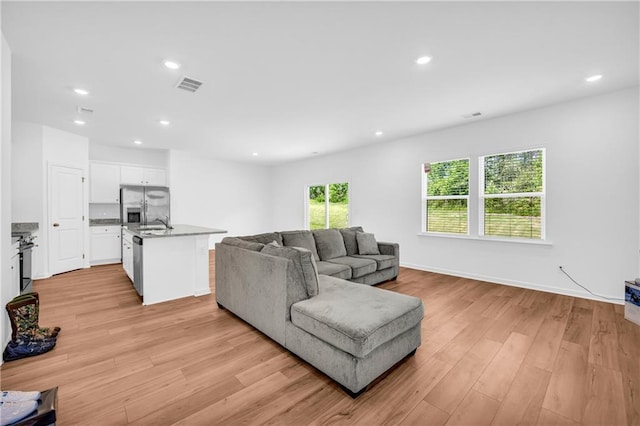 living area with recessed lighting, light wood-type flooring, and visible vents