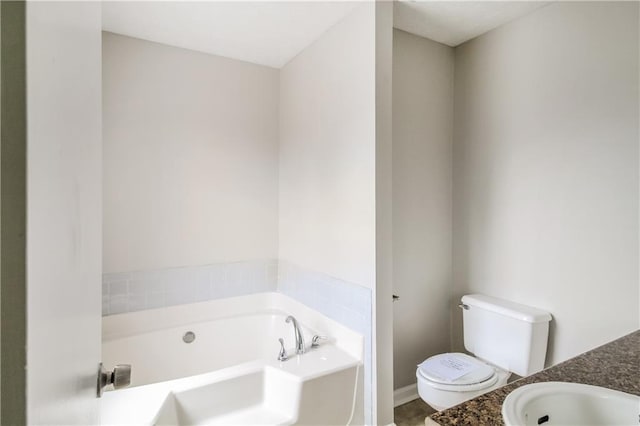 bathroom featuring a washtub, vanity, and toilet