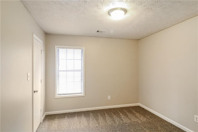 empty room with carpet flooring and a textured ceiling