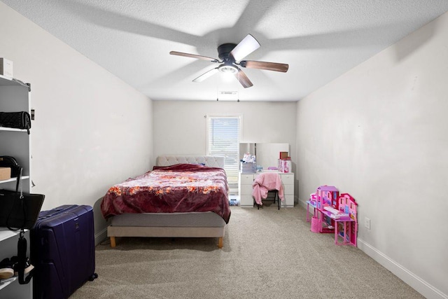 carpeted bedroom featuring baseboards, a ceiling fan, and visible vents