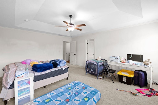bedroom featuring crown molding, ceiling fan, a tray ceiling, and carpet flooring