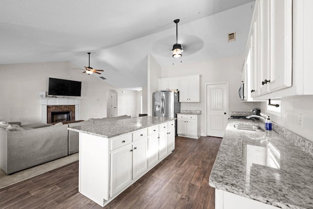 kitchen featuring visible vents, ceiling fan, white cabinets, stainless steel fridge with ice dispenser, and a sink