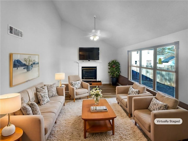 living room featuring lofted ceiling, hardwood / wood-style floors, and ceiling fan