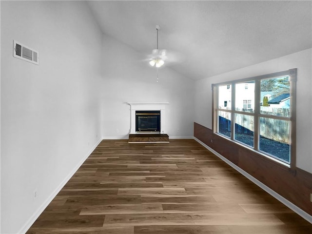 unfurnished living room with vaulted ceiling, dark wood-type flooring, and ceiling fan