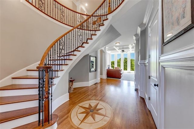 foyer with hardwood / wood-style flooring, a high ceiling, and ceiling fan