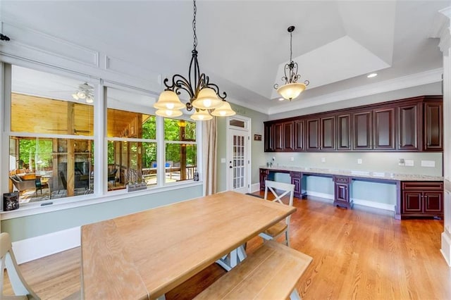 unfurnished dining area with ornamental molding, light hardwood / wood-style floors, and a raised ceiling