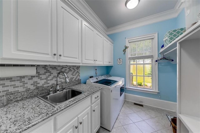 washroom featuring sink, washer and dryer, light tile patterned flooring, cabinets, and ornamental molding