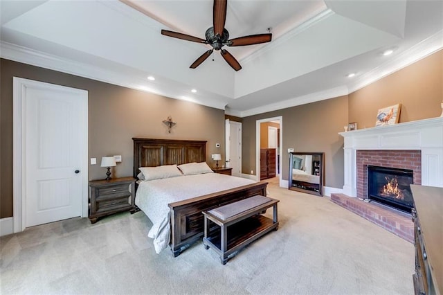 bedroom with ornamental molding, light colored carpet, ceiling fan, and a raised ceiling