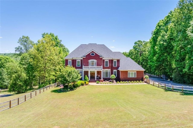 colonial inspired home with a front lawn