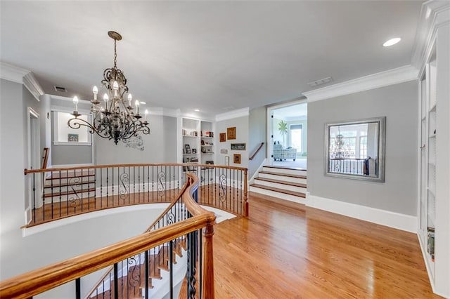 staircase with wood-type flooring, built in features, and crown molding