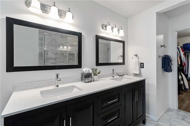 113 Regent Pl, Woodstock, GA 30188 - bathroom featuring double vanity, a walk in closet, marble look tile flooring, tiled shower, and baseboards