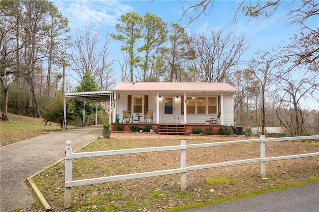 view of front facade with central AC, covered porch, and a carport