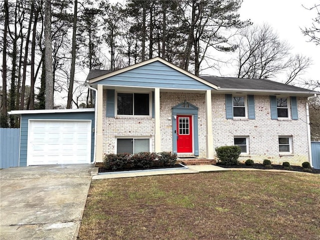 bi-level home featuring a garage and a front lawn