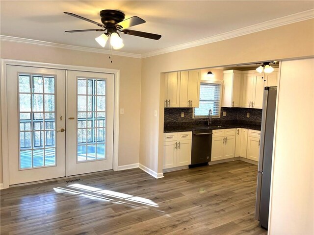 bathroom featuring a tile shower, crown molding, vanity, and toilet